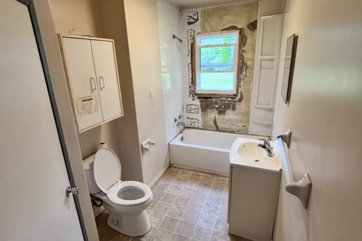 Bathroom during renovation with original vanity and tub